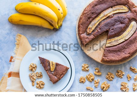 A piece of banana bread served on a ceramic plate with walnuts and selective focus.