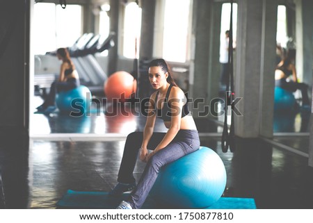Female athlete taking rest after exercising at gym. Fitness Healthy lifestye and workout at gym concept.