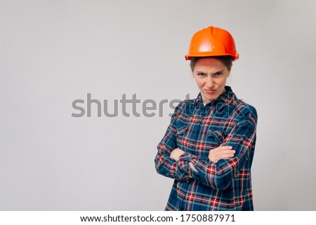 A portrait of a young evil girl builder looking into the camera. concept of job loss.
