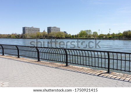 Empty Riverfront along the East River on the Upper East Side of New York City with a View of the Roosevelt Island Skyline