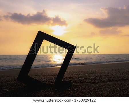 Photo frame on a sandy beach, beautiful sunset background, vintage slide