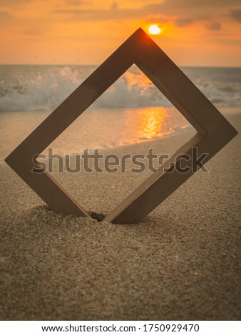 Photo frame on a sandy beach, beautiful sunset background, vintage slide
