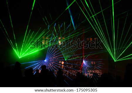 colorful laser show at night with audience on a place Royalty-Free Stock Photo #175095305