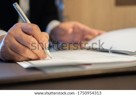 Asian Business people Manager checking and signing applicant filling documents reports papers company application form or registering claim on desk office. Document Report and business busy Concept