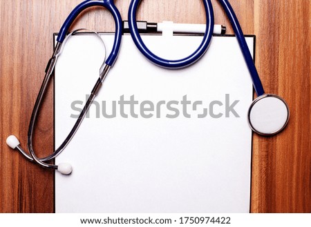 On a wooden table lies a tablet with a stethoscope. Medical concept. Place to insert text