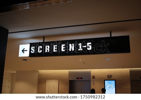 Movie theater sign hanging in shopping mall