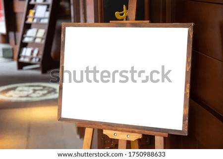 Blank advertisement wooden board at the entrance to shop or restaurant. Marketing and business mockup with blank billboard.