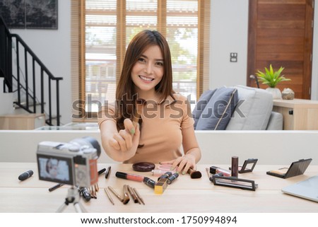 Attractive  young Asian woman live streaming, working at home. Concept of beauty blogger working, online selling, or shopping at home for stock photo. 