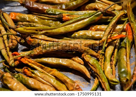 Stock photo of  dried green chillies stuffed with salt and coriander powder, kept under sunlight for drying at Bangalore, Karnataka, India. focus on object.