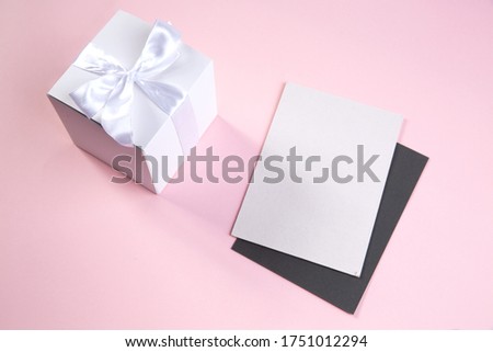 white gift box and greeting card for the holidays. delicate pink background. High quality photo