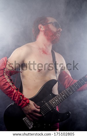 guitarist with electric guitar black, wearing face paint and red leather