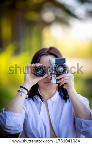 a girl holds the camera and the lens near the face