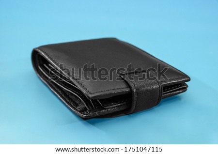 black men's wallet isolated on a blue background. Close-up.