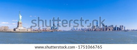 Panoramic landscape of Statue of Liberty with Manhattan downtown Skylines skyscraper building in background, NYC, New York State USA. New York Landmark Travel Destination and cityscape concept.