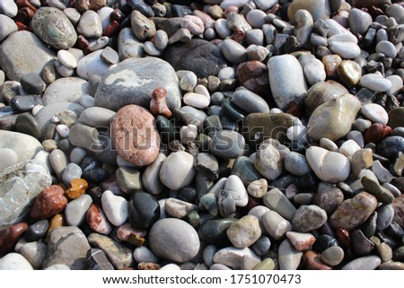 Texture and background of smooth sea stones from the coast in different sizes and colors