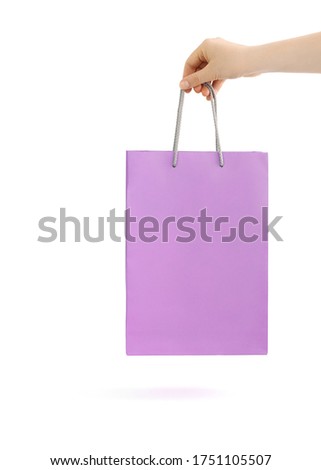 Lilac paper bag for shopping in hand.