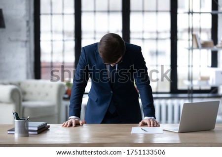 Upset unsuccessful Caucasian businessman stand at desk in office feel stressed after business startup failure, unhappy distressed male boss director stressed with company bankruptcy, money loss Royalty-Free Stock Photo #1751133506