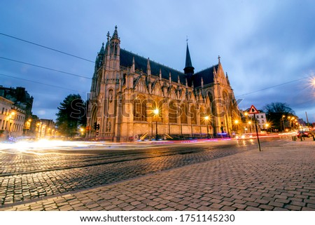 Long time exposure. Church Of Our Blessed Lady Of The Sablon at dusk or night. street lights on, clouds in the sky. 
