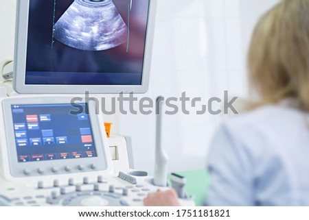 The doctor examines the patient on a computer. Ultrasound machine