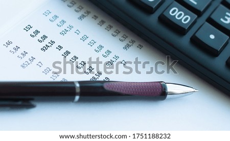Image of pen and calculator on a document with numbers.