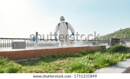 Sanitization, cleaning and disinfection of the city due to the emergence of the Covid19 virus. Specialized team in protective suits and masks at work near the riverside. Web Banner