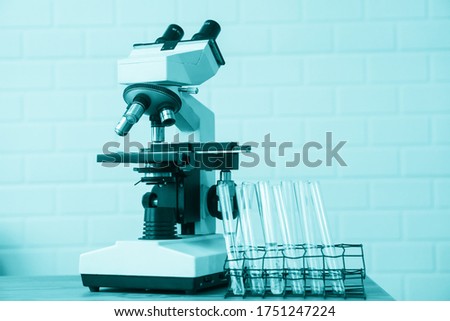 Tube and microscope with lab glassware, science laboratory research and development concept.Science,  chemistry, technology, biology and people concept