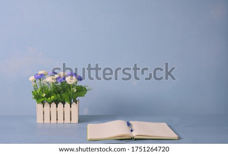Notebook and bouquet decoration on desk in workplace, pastel background, copy space, minimalism