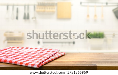 Red fabric,cloth on wood table top on blur kitchen counter (room)background.For montage product display or design key visual layout.