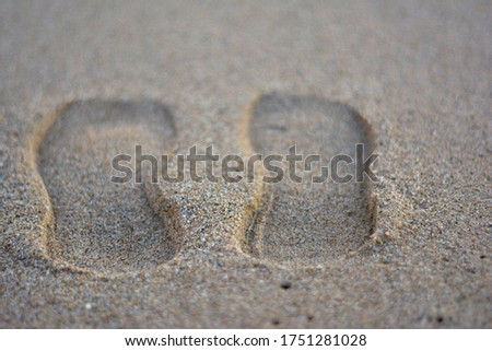 shoes print on sand beach of Barcelona