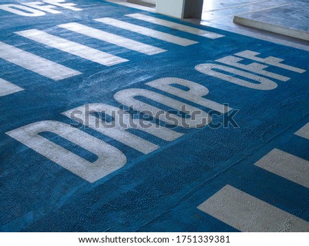 Drop off sign or drop off point on the floor with white text and blue background.