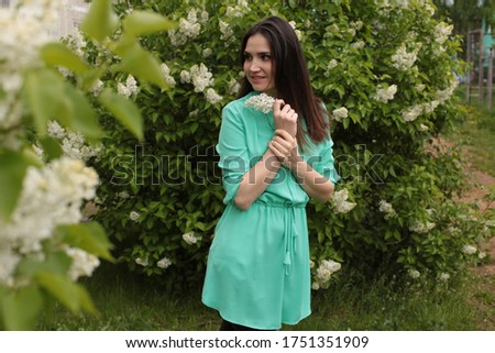  happy young girl with dark in a good mood in a spring blooming garden