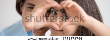 Close up photo little daughter and mother join fingers forming heart shape as concept sign of charity and donation, adoption kid and childcare, family bond. Horizontal banner for website header design Royalty-Free Stock Photo #1751378744