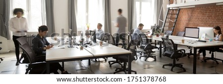 Group of multi ethnic corporate employees working in co-working open space walking in motion, sit at shared desks. Busy workday, office rush concept. Horizontal photo banner for website header design Royalty-Free Stock Photo #1751378768