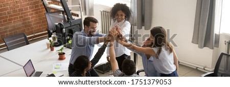Horizontal photo banner for website header design, above view group of multi ethnic businesspeople colleagues stack palms together giving high five celebrating common success. Team building concept
