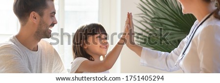 Little daughter gives high five to female doctor, pediatrician greets small kid girl patient, child healthcare medical check up, friendly relation concept. Horizontal banner for website header design Royalty-Free Stock Photo #1751405294