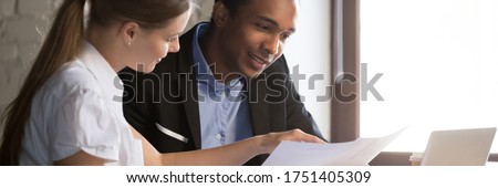 Multi ethnic colleagues analyzing report, financial advisor consult client people discuss agreement terms during meeting in office. Team work concept. Horizontal photo banner for website header design Royalty-Free Stock Photo #1751405309
