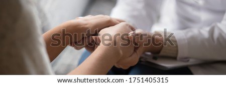 Psychologist in white coat holding hands of woman patient provide professional aid psychological help close up, show support express empathy concept. Horizontal photo banner for website header design