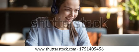 Woman wear headphones look at pc enjoy study online with tutor, listen audio lecture watch webinar prepare for exams, e-learn, self education concept. Horizontal photo banner for website header design Royalty-Free Stock Photo #1751405456