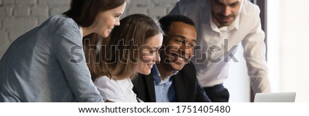 Horizontal photo banner for website header design, diverse employees gathered in office having fun watching funny video, discussing new ideas, brainstorming using laptop enjoy break in workday concept Royalty-Free Stock Photo #1751405480