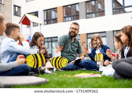 Group of cheerful children learning outdoors at school after covid-19 quarantine and lockdown. Royalty-Free Stock Photo #1751409362