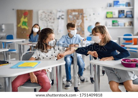 Children with face mask back at school after covid-19 quarantine and lockdown, greeting. Royalty-Free Stock Photo #1751409818