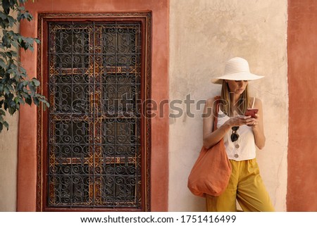 Stylish woman texting in traditional moroccan riad