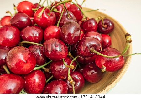 close up red cherries in bowl on white background