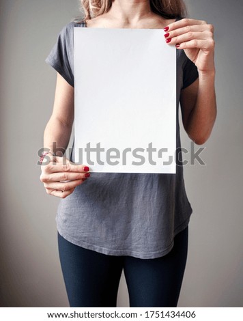 Caucasian woman girl holding blank white paper sheet with copy space
