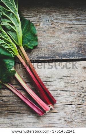 Fresh rhubarb with leaves close up on a wooden background