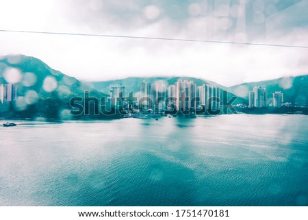 tung chung bay of hong kong in rainy day with water drop on glass, view from ngong ping cable car. toned photo