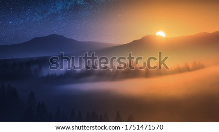 Day and night. The rising sun and night starry sky over the foggy mountain valley. Fairytale conceptual landscape.