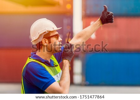 Foreman shipping staff worker working radio control loading cargo port logistic for import export goods at container warehouse. Royalty-Free Stock Photo #1751477864