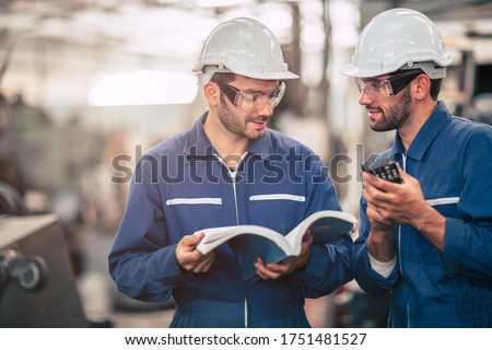 Engineer team talking together teach and learn engineering technical about using machine with open instruction manual text book in factory workplace. Royalty-Free Stock Photo #1751481527