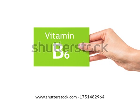 Vitamin B6. Female hand shows a card with the inscription Vitamin B6.